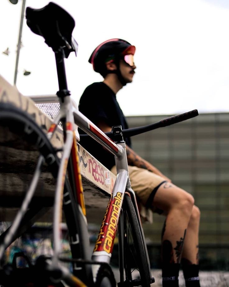 a man sitting on top of a bench next to a bike