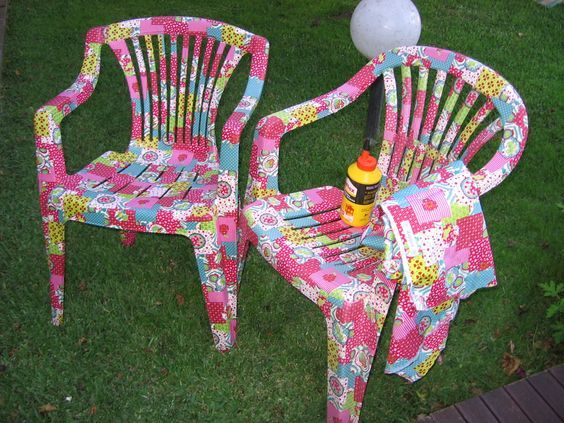 two colorful chairs sitting on top of a lush green field