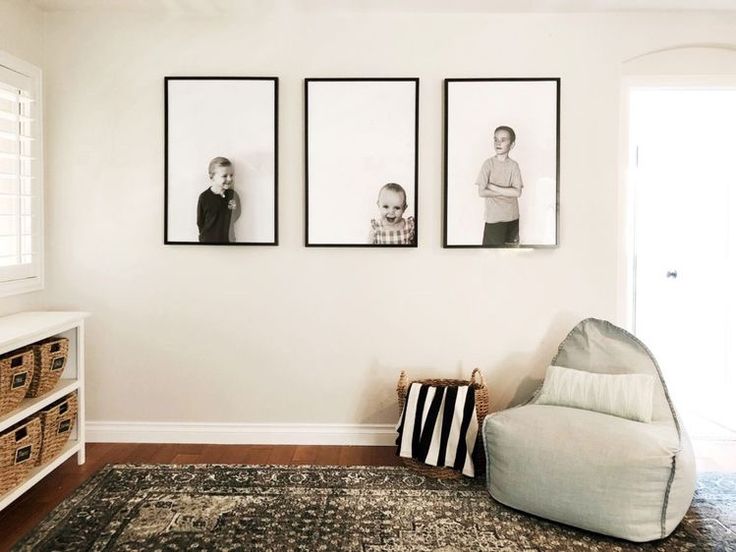 three black and white photos hang on the wall above a chair in a living room