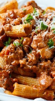 pasta with meat sauce and parmesan cheese in a white bowl on a table