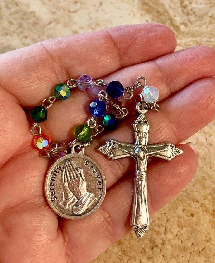 This is a beautiful one-decade Serenity prayer rosary. The total length is 8 1/4 inches. A great way to remember to pray anytime, anywhere! This will make a very meaningful gift to treasure for yourself or for someone else you really care about! Beads: I alternated an array of beautiful rainbow crystal beads for the ten Hail Marys and single Our Father. Medals: It features a 1 inch round Serenity prayer medal with the actual prayer on the reverse side. The flared Crucifix is 1 1/2 inches. The me Healing Rosary With Miraculous Medal And Round Beads, Healing Rosary With Miraculous Medal, Spiritual Beaded Rosary For Blessing, Spiritual Rosary With 8mm Beads For Blessing, Multicolor Spiritual Rosary Bracelet With 8mm Beads, Spiritual Rosary With 8mm Beads, Spiritual Rosary With 108 Beads And Crucifix, Spiritual Beaded Rosary Bracelet For Blessing, Nickel-free Spiritual Rosary Bracelet Gift