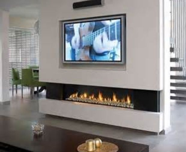 a flat screen tv mounted on the wall above a fireplace in a modern living room