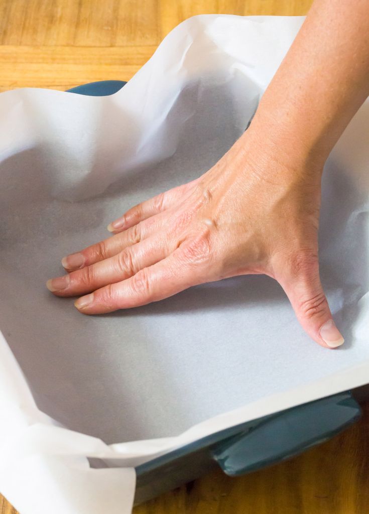 a person's hand on top of a piece of paper that is sitting on a table