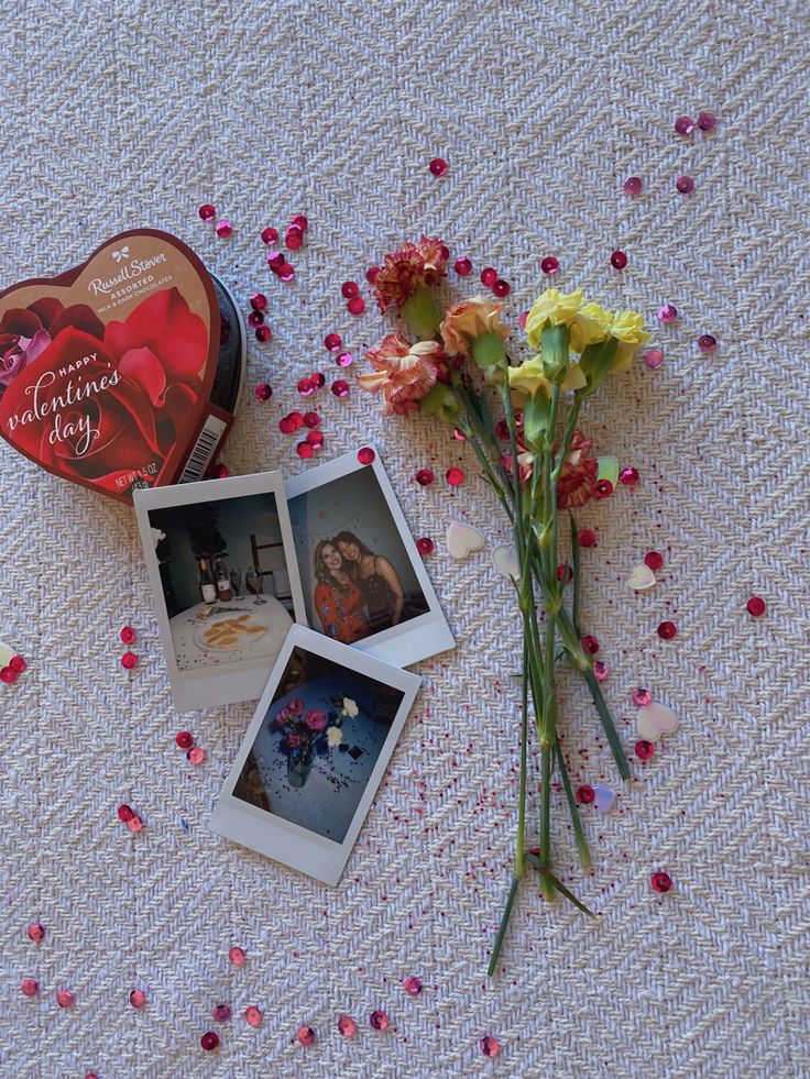 some flowers and pictures are laying on a table with confetti sprinkled around them