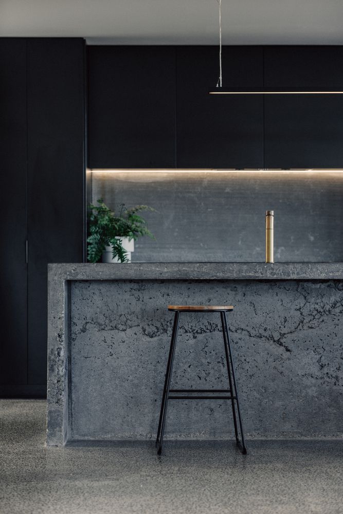 a bar with stools in front of it and a potted plant on the counter