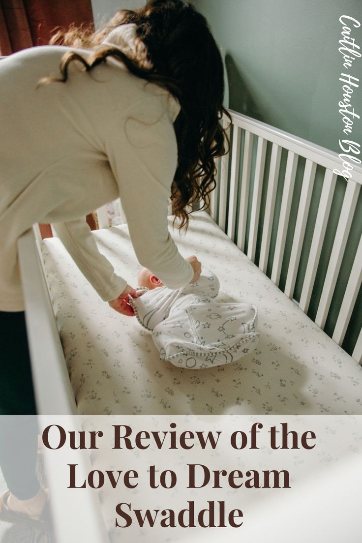 a woman reaching into a crib with a baby in it and the words, our review of the love to dream swaddle