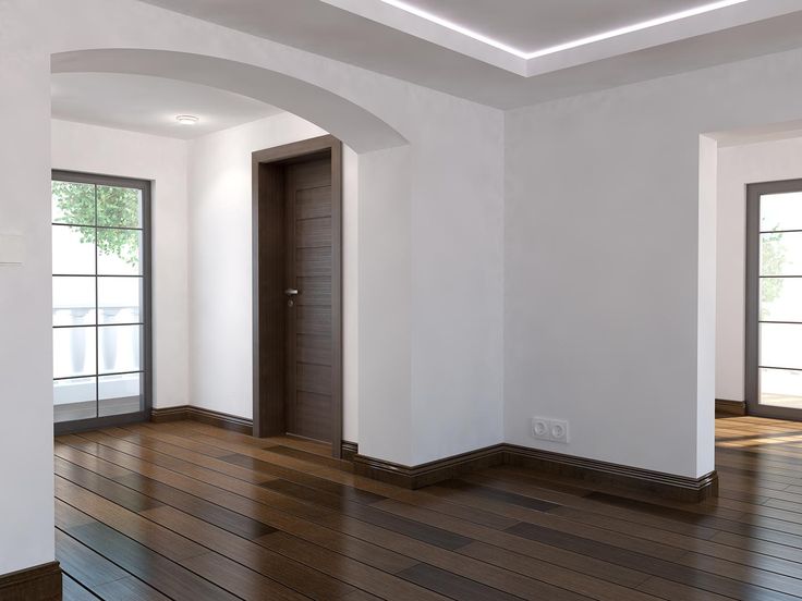 an empty room with wood flooring and two open doors on the wall to the left