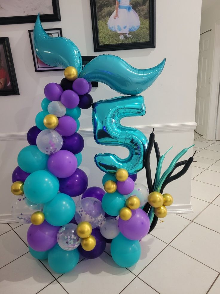 balloons are arranged in the shape of a number five and mermaid tail for a birthday party