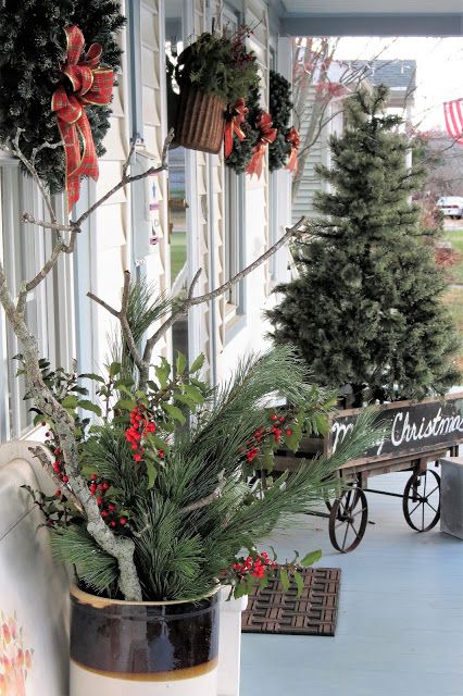 a potted plant sitting on top of a wooden table next to a building with christmas decorations