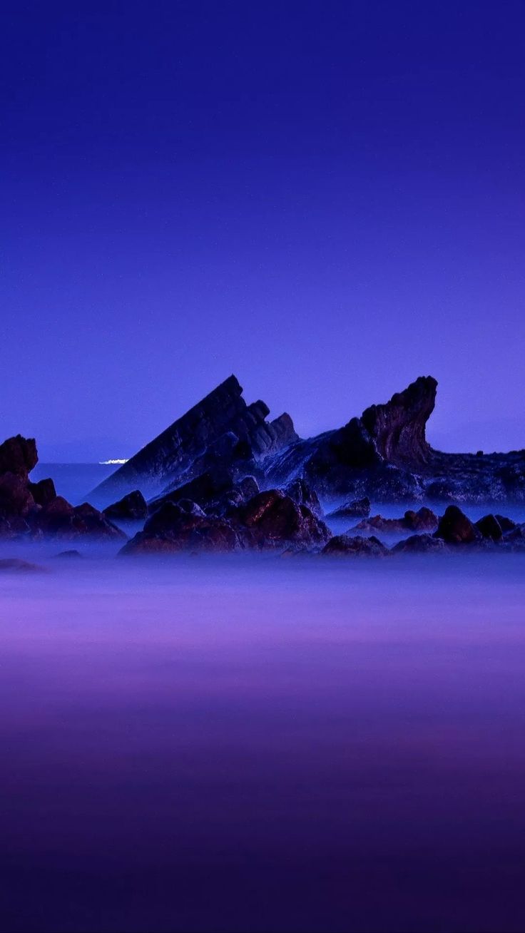 the rocks are covered in purple light as the sun sets