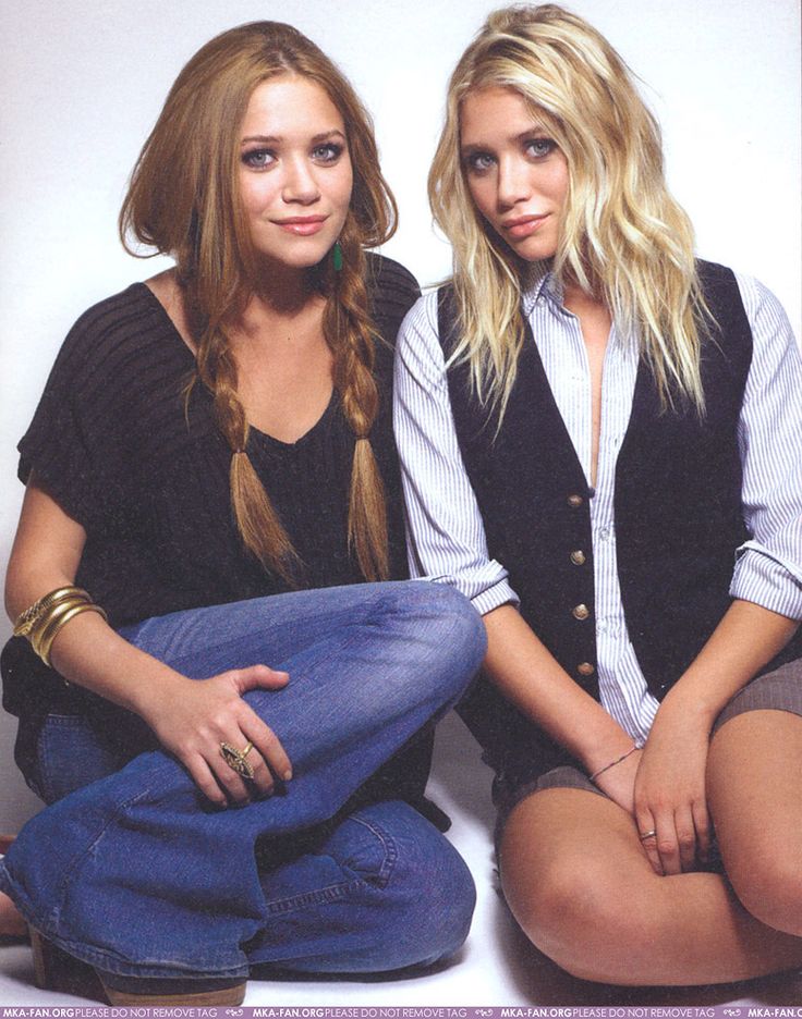 two beautiful young women sitting next to each other on top of a magazine pages cover