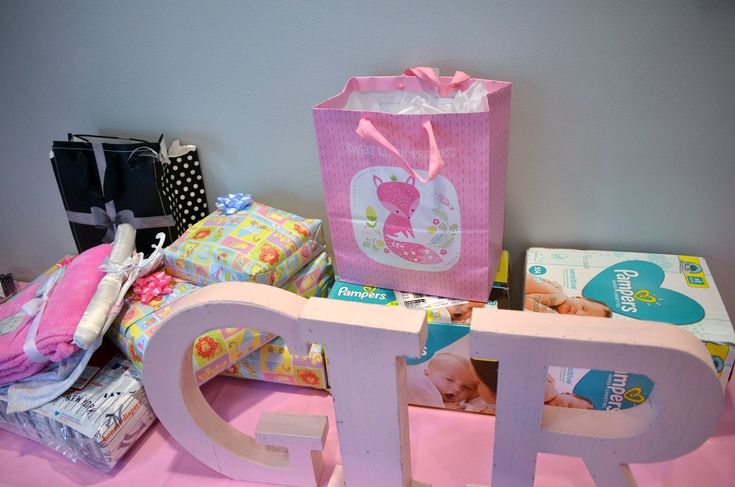 a pink bag sitting on top of a table next to some boxes and other items