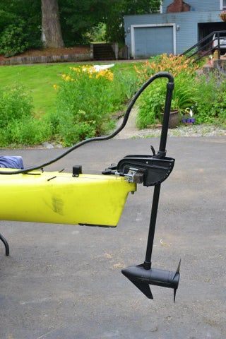 a yellow kayak is hooked up to a black pole with an arrow on it