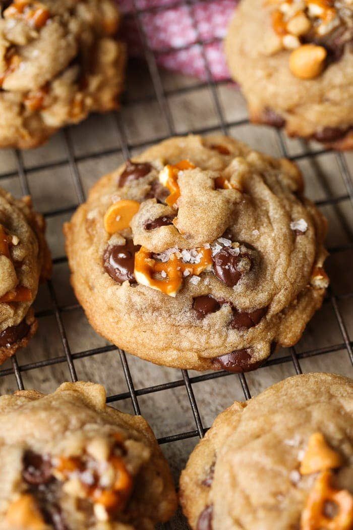 chocolate chip cookies on a cooling rack with orange peels and chopped walnuts in the middle