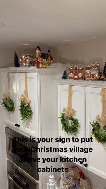 a kitchen decorated for christmas with wreaths on the cabinets and garland around the oven