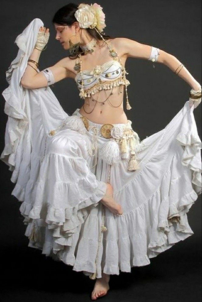 a belly dancer is posing for the camera with her hands on her hips and arms behind her head