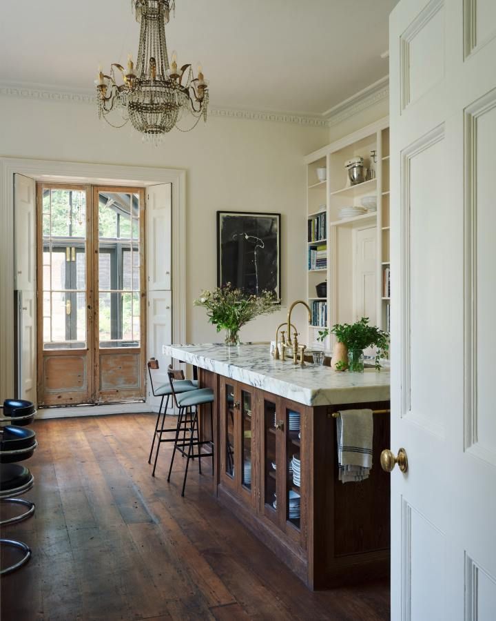 a large kitchen with wooden floors and white walls