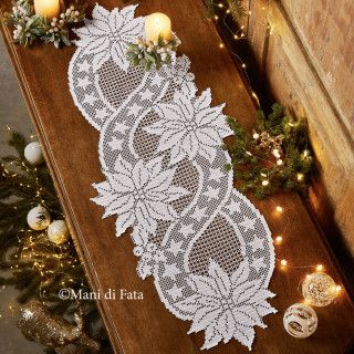 the table runner is decorated with white lace and christmas decorations on it, along with candles