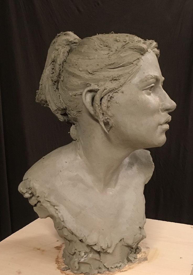 a clay sculpture of a woman's head on a table