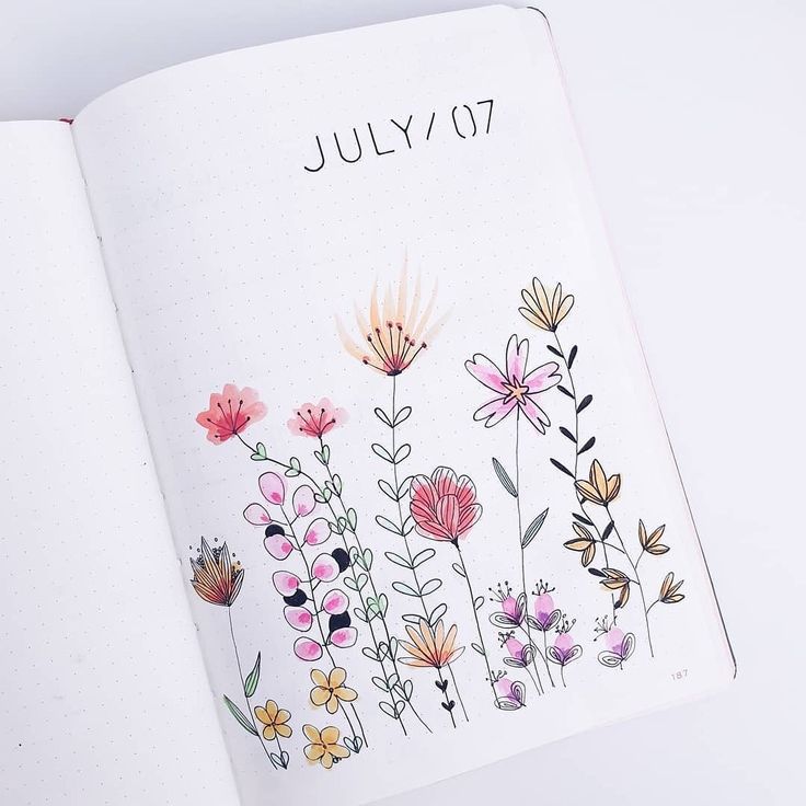 an open notebook with flowers drawn on the pages and in it is a page that says july