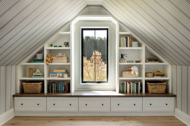 an attic bedroom with built in bookshelves and shelves