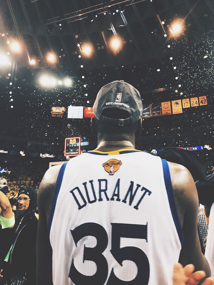 the back of a basketball player's jersey as he stands in front of an audience