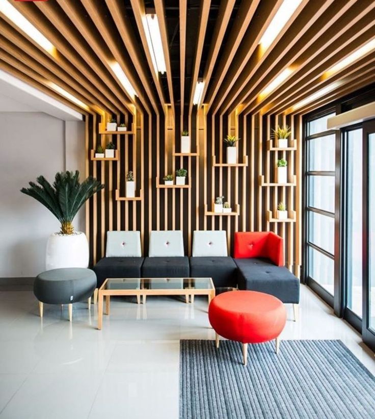 a living room filled with lots of furniture next to a large glass window covered in wooden slats