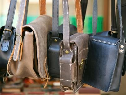 several purses hanging from hooks in a row