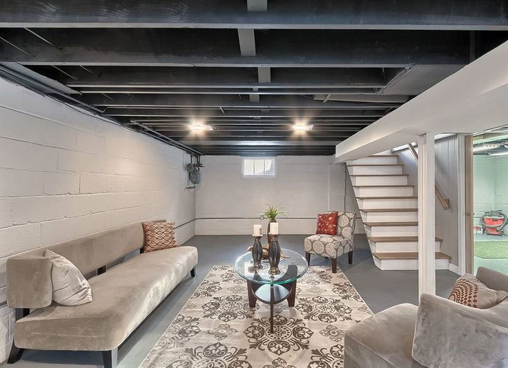 a living room with couches, chairs and a rug on the floor in front of stairs