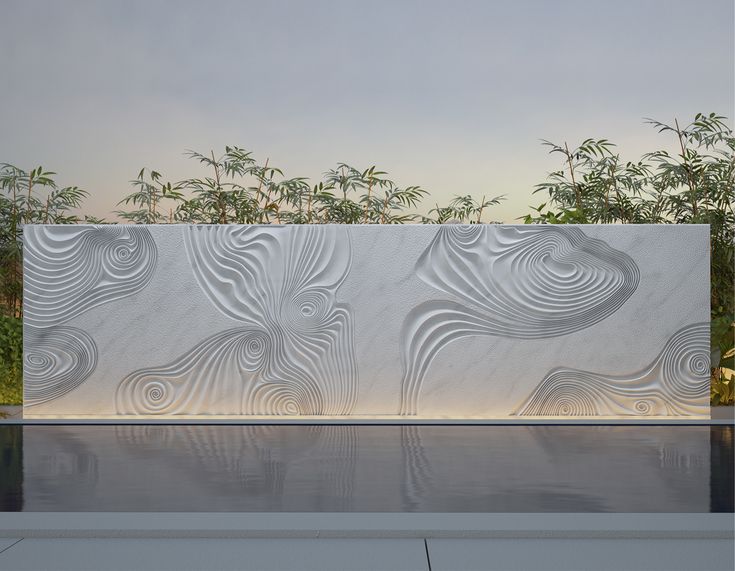 an artisticly designed wall next to a pool