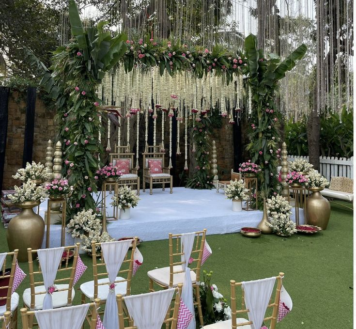 an outdoor ceremony setup with white and pink flowers