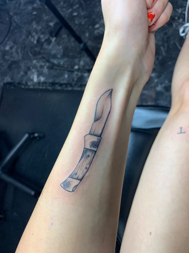 two people with tattoos on their arms holding onto each other's legs and one has a knife in it