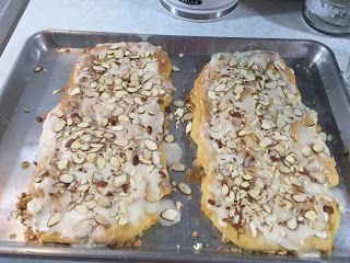 two pieces of bread covered in nuts on a pan