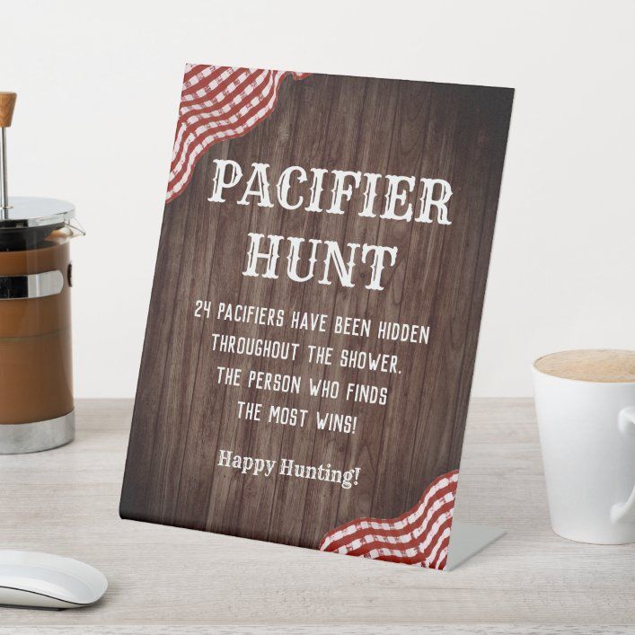 a wooden sign sitting on top of a table next to a cup and saucer