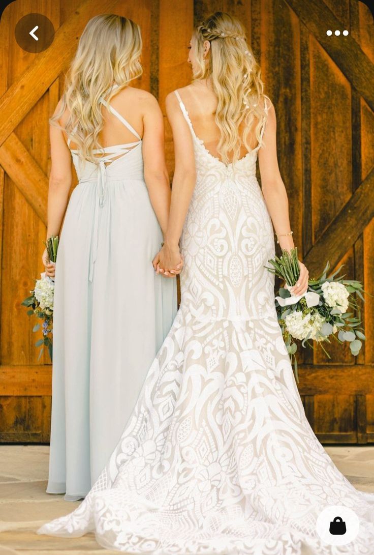 two brides holding hands in front of a barn door