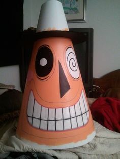 an orange and white plastic cone shaped like a face