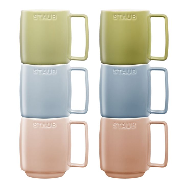 four pastel mugs with the word staub on them in different colors