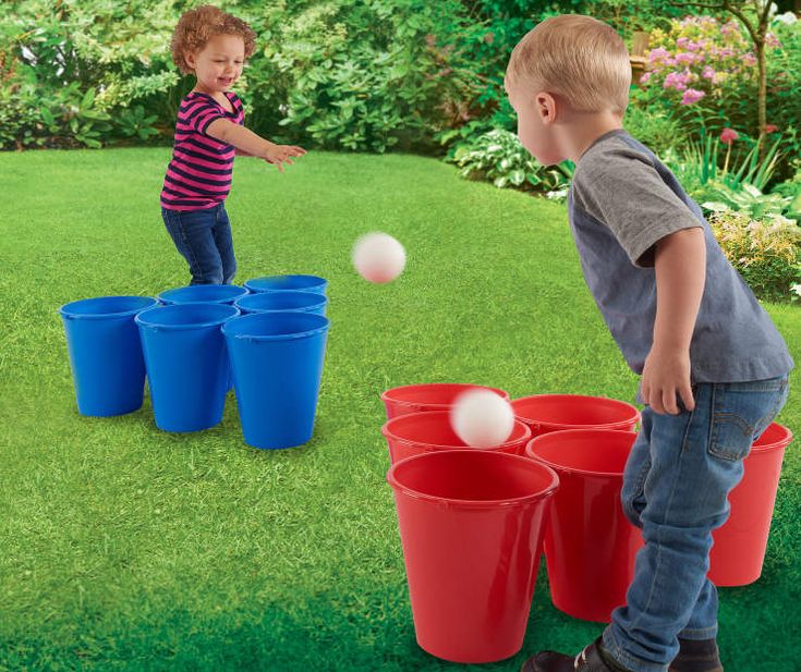 two young boys playing with plastic buckets and balls