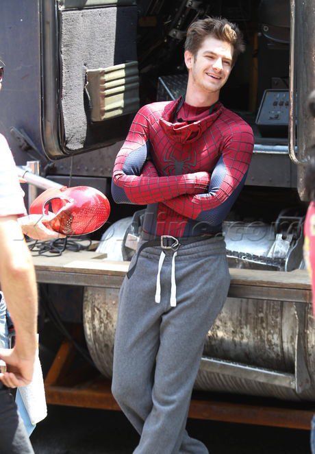 a man in spider - man costume standing next to a truck