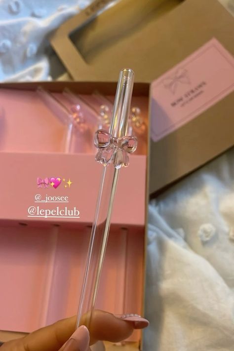 a person is holding a crystal wand in their hand next to a pink gift box