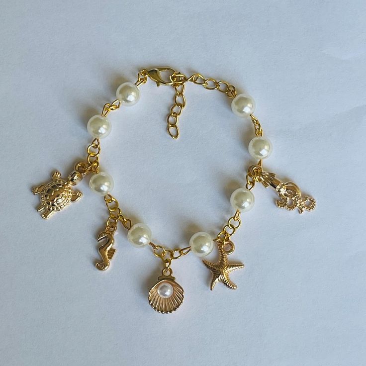 gold marine animals | dainty handmade charm bracelet Affordable White Charm Bracelet For Beach, Dainty Gold Bracelets For Beach, Dainty Bracelet With Adjustable Chain, Beach Charms Bracelet Jewelry, Dainty Adjustable Bracelet For Beach, Elegant Adjustable Charm Bracelet For Beach, Dangle Bracelets With Pearl Charm As Gift, Pearl Charm Dangle Bracelets As Gift, Dainty Adjustable Chain Bracelet For Beach