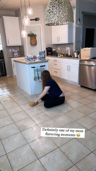 a person kneeling on the floor in a kitchen