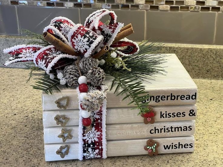 a stack of books with christmas decorations on top