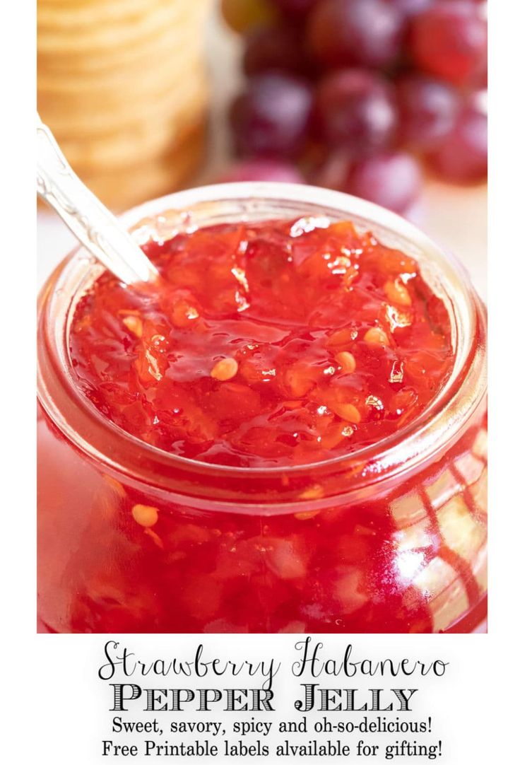 strawberry jalapeno jelly in a glass jar with a spoon on the side