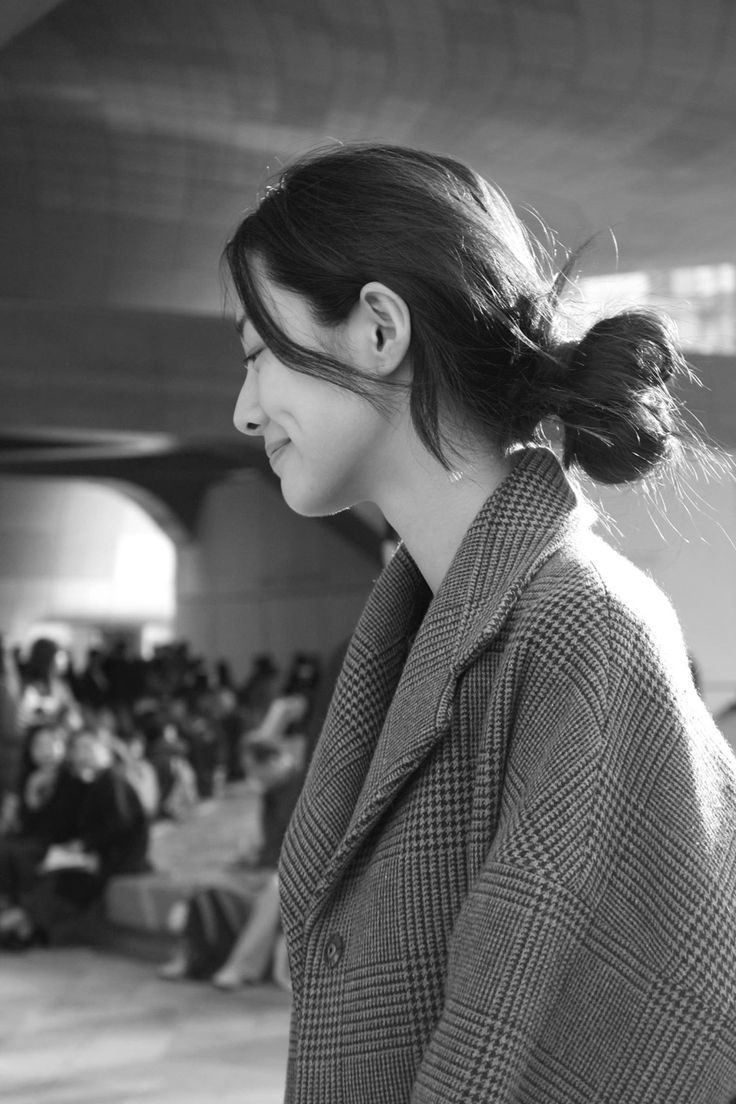 black and white photograph of a woman in front of an audience at a fashion show