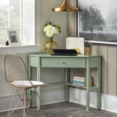 a desk with a chair, lamp and pictures on the wall