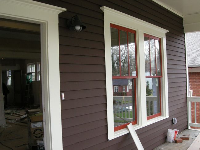 a house with brown siding and white trim on the front door, windows are missing