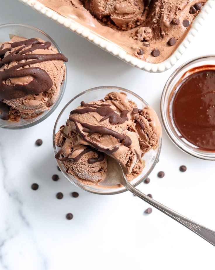 three bowls filled with ice cream and chocolate sauce