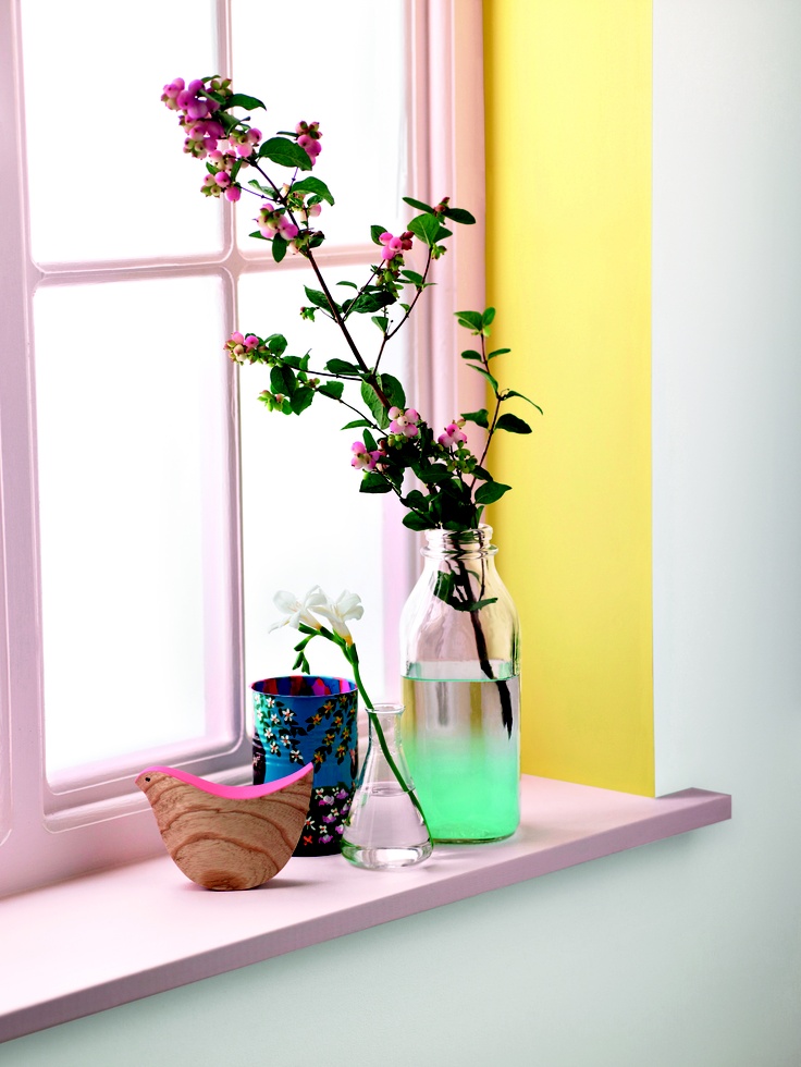 a vase filled with flowers sitting on top of a window sill next to a flower pot