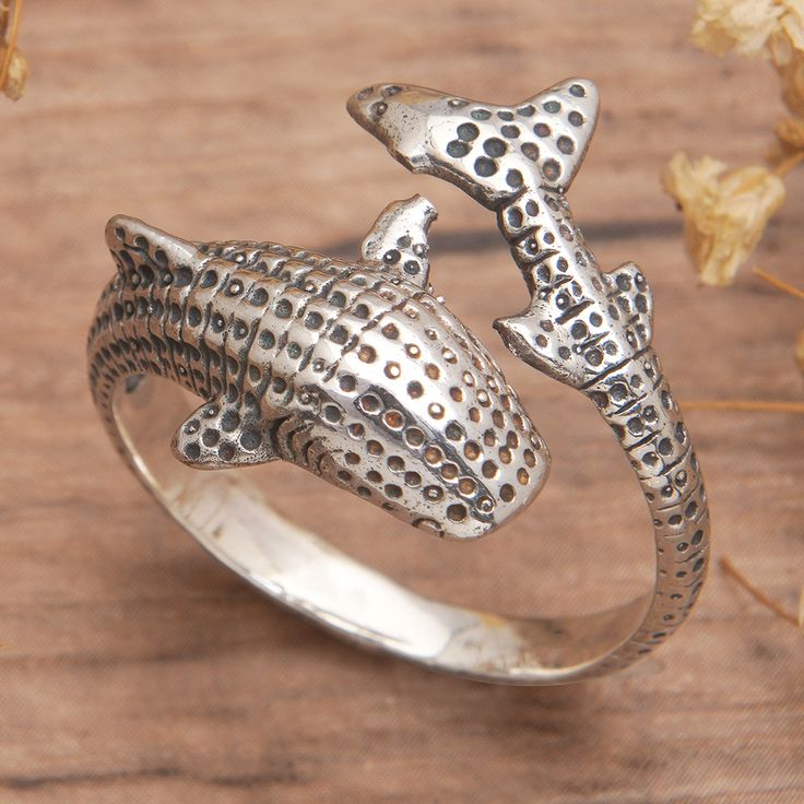 The mysterious ocean depths hide treasures and marvels, once protected by a magnificent shark called the megalodon. Symbol of heroism, protection and tenacity, this ancient species is today the main inspiration for Balinese artisan Giri Tasmana, who captures the shark's grandeur in a sterling silver wrap ring accented with a dot pattern. Shark Rings Jewelry, Accessories For Characters, Nature Rings, Shark Ring, Style 2025, Whale Jewelry, Silver Wrap Ring, Artisan Rings, Nature Ring